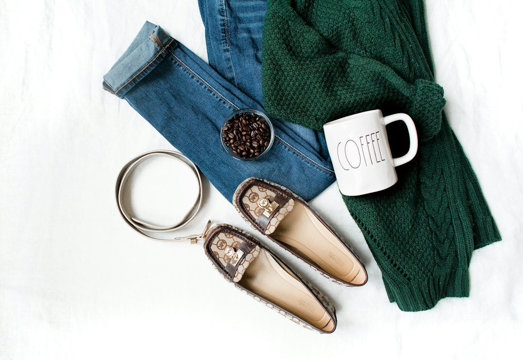 Neutral fall wardrobe pieces and footwear arranged for a capsule wardrobe